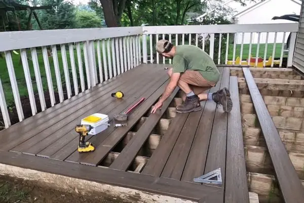 a man installing new wooden deck